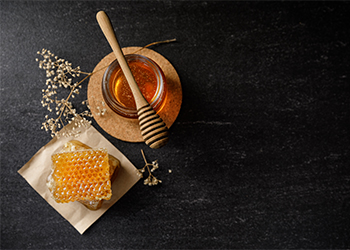 Honey,Bee,And,Honeycomb,With,Honey,Dipper,And,Dry,Flower